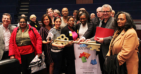 "Close the Housing Gap" rally speakers and community activists: Nicole Waldron (Centre in pink sweater and black blazer) is flanked by Harvey Cooper (far left), Managing Director -- Ontario Region, CHF Canada; Toronto city councillor, Ana Bailao (front row, fourth from left); Michelle Moldanado, CHF Canada Director (front row, fifth from left); Karyn Moore, - CHF-Toronto Board Member (front row, fourth from right); MP Adam Vaughan (second from right); and unnamed supporters. Photo courtesy of CHF-Toronto.