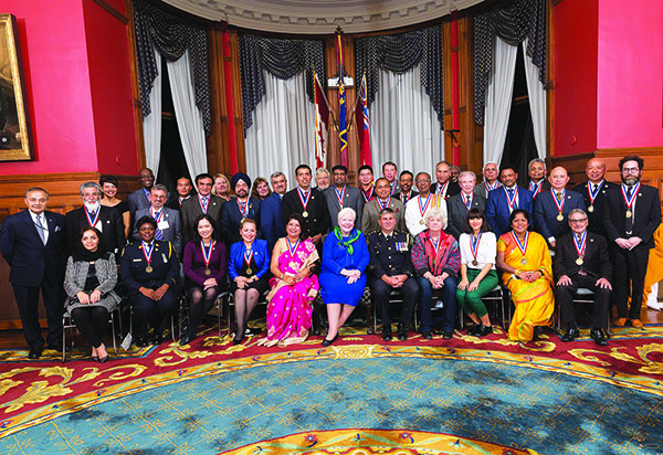 The 2015 NEPMCC award recipients pose for a group photo with the Honourable Elizabeth Dowdeswell, Lieutenant Governor of Ontario (seated, center); Thomas Saras (standing, extreme left), NEPMCC President; and Maria Saras-Voutsinas (standing, third from left), the Executive Director of the national media organization, who read the citations for the event. Photo credit: youradonline.ca. 