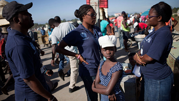 A girl waits with officers from the Haitian Police's Brigade for the Protection of Minors (BPM) in the city of Ouanaminthe, on the north-eastern border with the Dominican Republic. BPM is a UNICEF partner in combating child trafficking. Photo credit: UNICEF/Marco Dormino.
