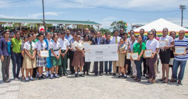 Prime Minister Moses Nagamootoo (centre, behind cheque, in suit) with the recipients of grants under the STEAM Initiative. Photo credit: GINA.