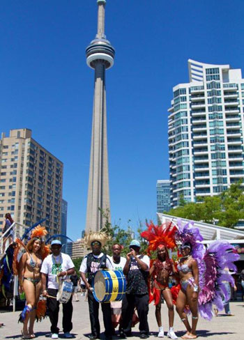 Last year's "Barbados on the Water" masqueraders and musicians pose in front of the CN Tower in Toronto. Photo courtesy of Barbados Tourism Marketing Inc.