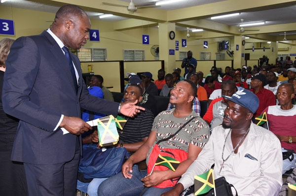 State Minister for Labour and Social Security, Zavia Mayne (left), offers words of advice to farm-workers, during a send-off ceremony at the Ministry of Labour and Social Security’s Overseas Employment Services Centre, on Friday (January 3). They are (from right): Maurice Harvey, Trevayne Gayle, and Dwyaine Mitchell. Photo credit: Rudranath Fraser/JIS.