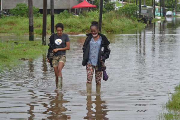 Georgetown residents wade through flood waters. Photo credit: DPI.