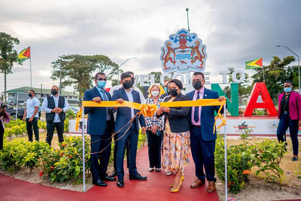 Guyana's First Lady, Arya Ali, cuts the ceremonial ribbon to launch the “Welcome to Guyana” sign at the CJIA.