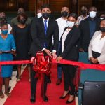 Guyana's Minister of Culture, Youth and Sport, Charles Ramson Jr, cutting the ribbon to celebrate the new theatre seats at the National Cultural Center. Photo credit: GDPI.